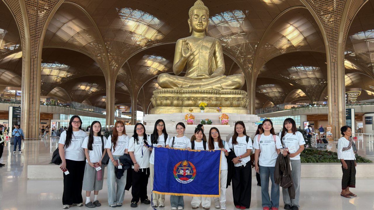 International Business students with the Cambodian flag at Techo International Airport before departing on exchange